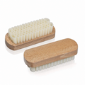 Two wooden shoe brushes with white bristles on a white background